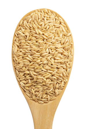 top view of oats grain with wooden spoon isolated on white backgroundの写真素材
