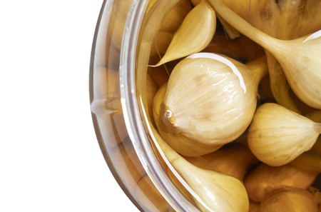 close up jar of garlic pickle in vinegar and salt isolated on white backgroundの写真素材