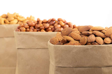 roasted almonds in brown baper bag  on white backgroundの写真素材