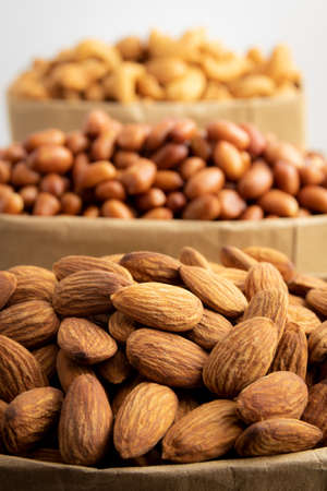 roasted almonds in brown baper bag  on a white background