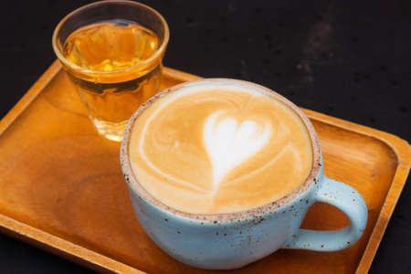 cup of coffee latte with hot tea on brown wooden tray