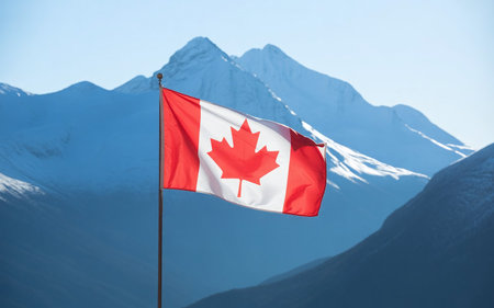 Canadian flag waving in the wind against the background of the mountains.の素材