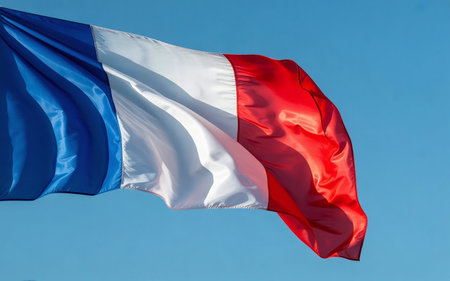 French flag waving in the wind on blue sky background. Close up.の素材
