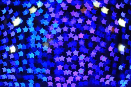 Blue star shape light bokeh background, from nightlife city and festive Christmas night decoration.の写真素材