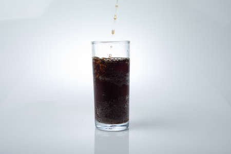 Glasses with sweet drinks with ice cubes isolated on whiteの写真素材