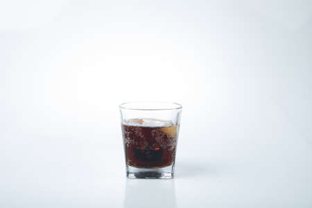 Glasses with sweet drinks with ice cubes isolated on whiteの写真素材