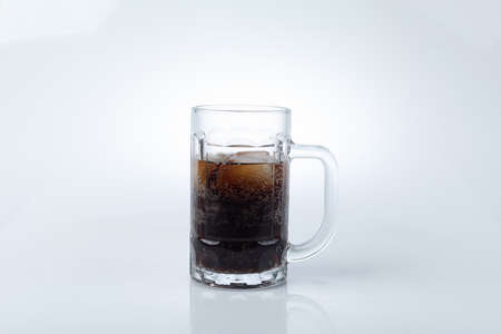 Glasses with sweet drinks with ice cubes isolated on white