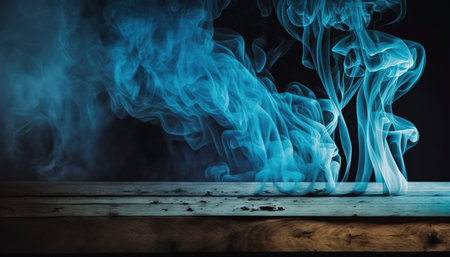 Smoke from incense stick on a wooden table against black backgroundの写真素材
