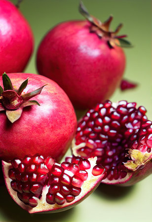 Ripe pomegranate fruit on green background, closeup. generative aiの素材