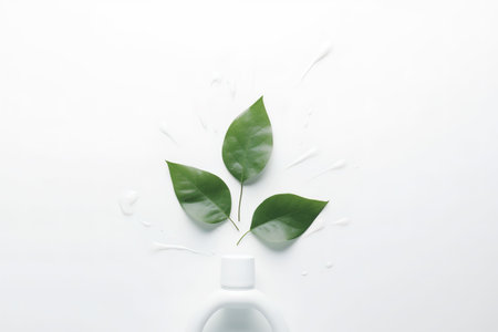 White bottle of cosmetic cream with green leaves on white background, top viewの素材