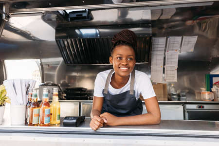 Portrait of young small business owner standing in her food truck waiting for clientsの写真素材