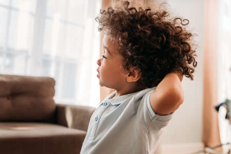 Close up of a cute little boy standing at home with closed eyesの写真素材