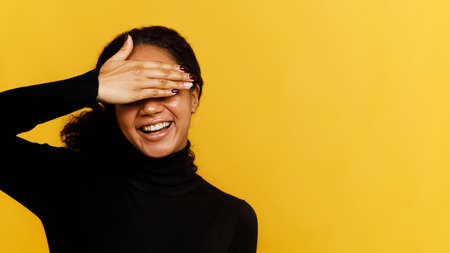 Front view of a beautiful brunette woman over yellow backgroundの写真素材