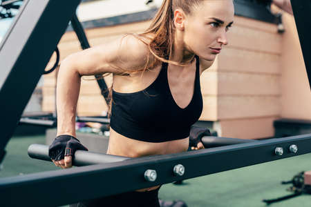 Side view of woman athlete doing triceps dip at power rackの写真素材