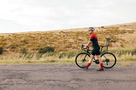 Woman cyclist sitting on her bike resting during outdoors rideの写真素材