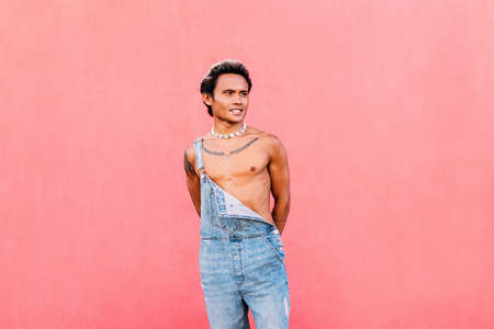 Portrait of a young happy guy with rainbow LGBT flag looking at cameraの写真素材