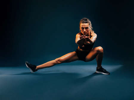Strong woman in fitness wear showing her biceps. Young healthy female in sports clothes.