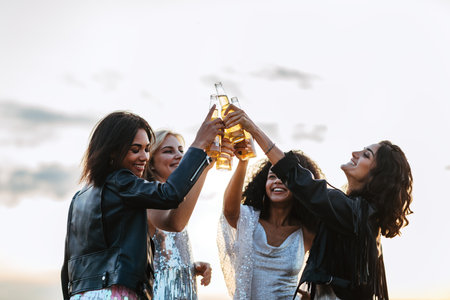 Smiling female friends holding instant photographs outdoorsの写真素材