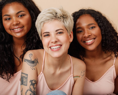 Group portrait of three diverse women in the studio. Female with different skin colors sitting together.の写真素材