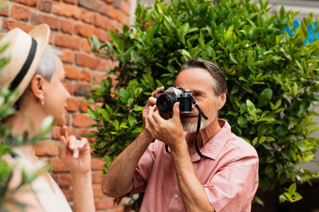 Senior male doing photographs of her wife in the parkの写真素材