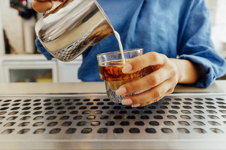 Close up of female barista making a flat white coffeeの写真素材