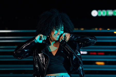 Happy woman in white bathrobe touching her cheeks. Young female looking in her reflection in bathroom mirror.の写真素材