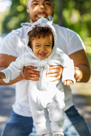 Happy cute boy in costume looking at camera while father holding him