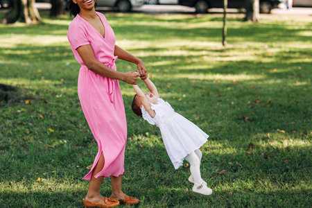 Young mother and her little daughter having fun outdoors on a sunny dayの写真素材
