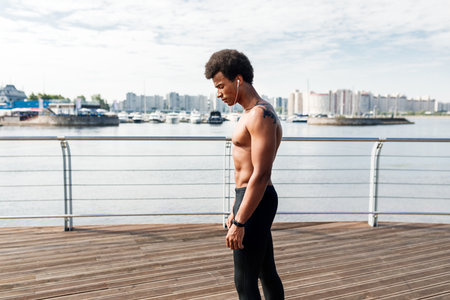 Side view of muscular runner listening to musicの写真素材