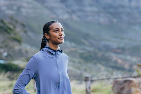 Portrait of a positive woman enjoying a morning walk against a stunning view in the natural parkの写真素材