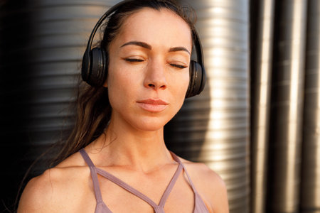 Close-up high-detailed portrait of a young woman during a workout break. Fitness female with closed...