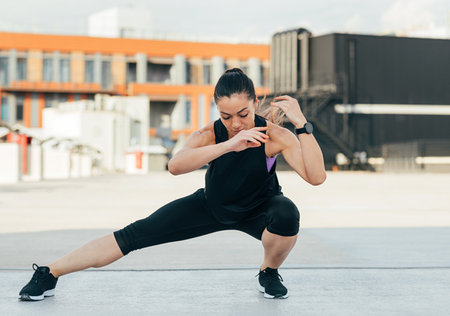 Young female doing warming-up exercises. Woman in sportswear warming up her legs.