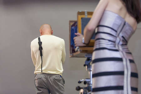 girl makes a photograph of man with vintage cameraの写真素材