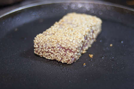 fried tuna steak on the hot pan closeup shotの写真素材