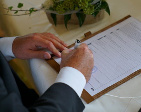 caucasian groom signing for marriage in civil registry officeの写真素材