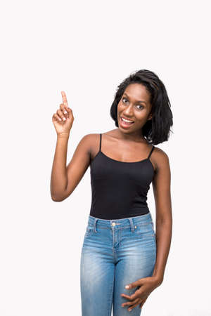 Woman pointing up and looking at cameraの写真素材