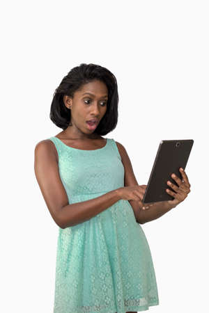 Shocked woman using digital tabletの写真素材
