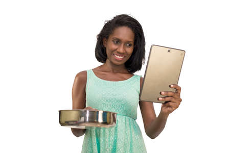 Smiling woman holding pan and tabletの写真素材