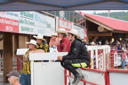 Williams Lake, British Columbia/Canada - July 1, 2016: group of cowboys sit by the chutes watching the Mountain Race at the 90th Williams Lake Stampede, one of the largest stampedes in North Americaのeditorial素材
