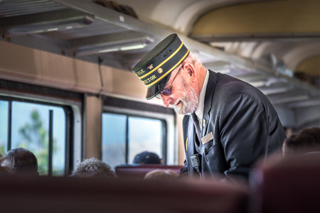 Summerland, British Columbia/Canada - May 14, 2017: the conductor takes tickets from passengers on the Kettle Valley Steam Railway, a popular tourist attraction in the Okanagan.のeditorial素材