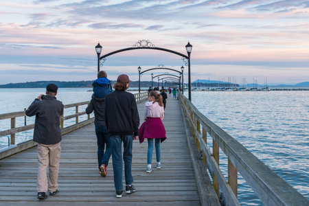 White Rock, British Columbia/Canada - June 10, 2017: a family walks down the White Rock Pier at sunset. The pier, built in the 1920's, is a popular tourist attraction.のeditorial素材