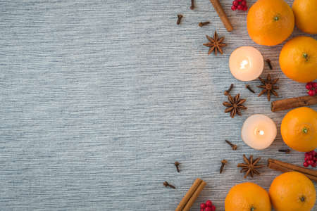 Flat lay seasonal arrangement of oranges, spices, and candlesの写真素材