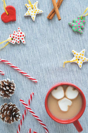 Handmade tree ornaments with mug of hot cocoa, candy canes, and pinecones