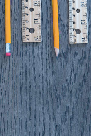 Pencils and rulers on gray wood grain background flat lay arrangementの写真素材