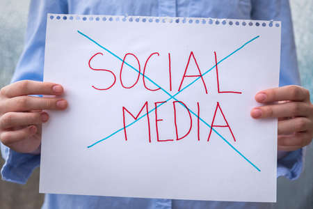 Close-up of sign held in front of person with the words social media crossed out to illustrate the growing trend of deleting social media accountsの写真素材