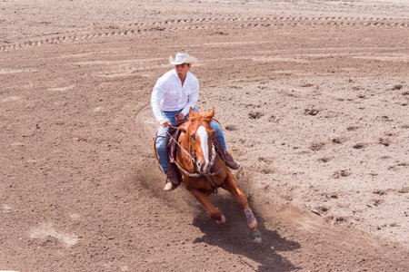 Williams Lake, British Columbia/Canada - June 19, 2016: cowboy and horse take a tight turn in barrel racing event called the Stampede Warm-Up to prepare for the Williams Lake Stampede, one of the largest stampedes in North Americaのeditorial素材