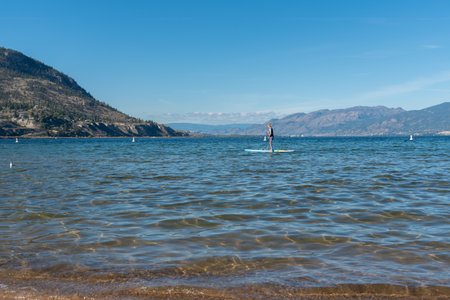 Penticton, British Columbia/Canada - September 21, 2019: woman rowing paddle board across Okanagan Lake on sunny day, a popular summer activityのeditorial素材