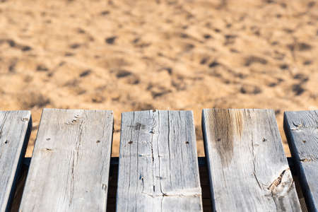 Close-up of gray and weathered wood with beach sand in backgroundの写真素材