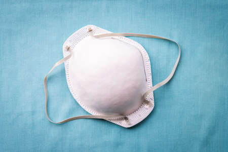 N95 protective face mask on solid blue background