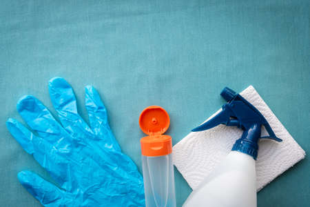 Flay-lay photo of surgical glove, bottle of hand sanitizer, cleaning spray and paper towel with copy spaceの写真素材